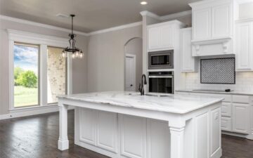 photo of a kitchen interior of a home for sale showing a counter top, oven, and open window with view of back yard