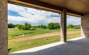 photo from the interior of a garage facing sprawling land surrounded by trees